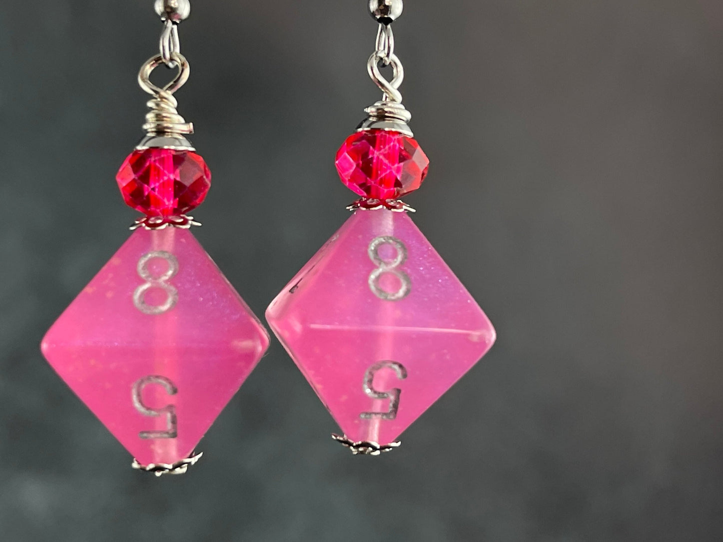 Pink Borealis D8  dice earrings glowing in the dark