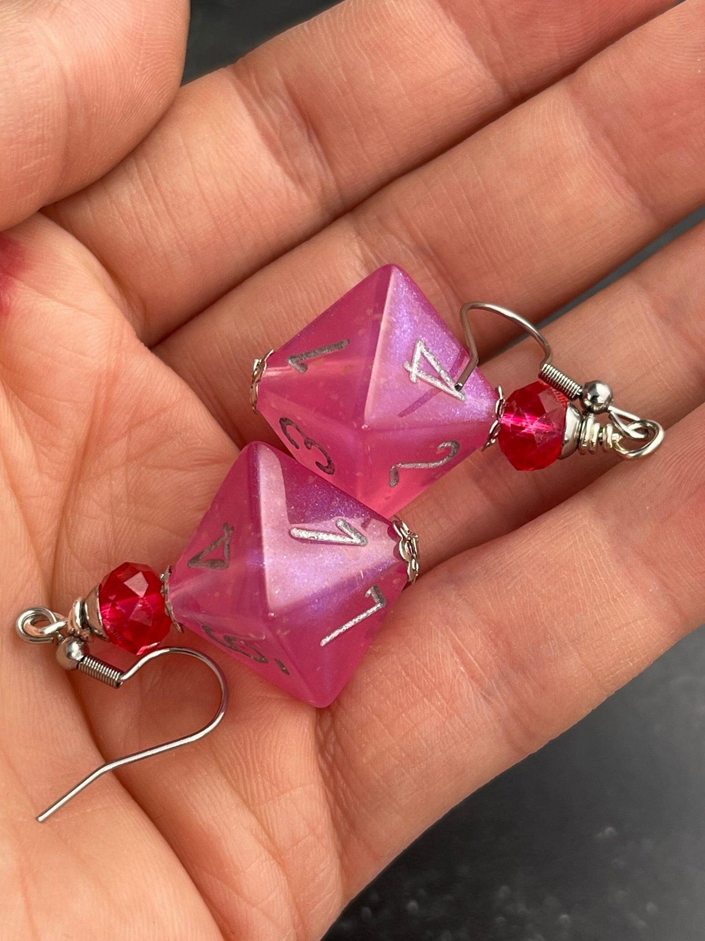 Pink Borealis D8  dice earrings glowing in the dark