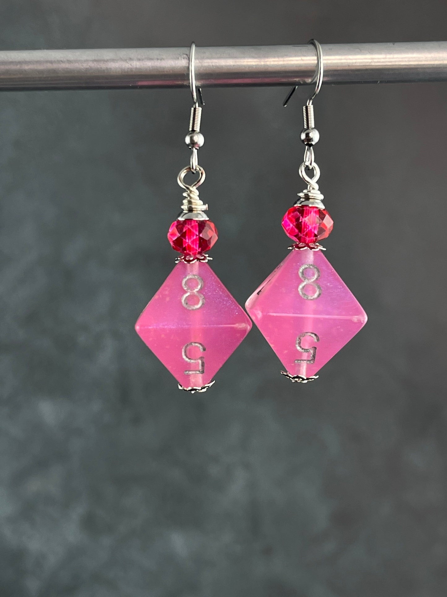 Pink Borealis D8  dice earrings glowing in the dark